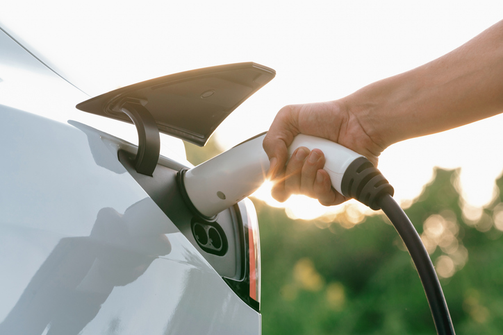 Man recharging battery for electric car