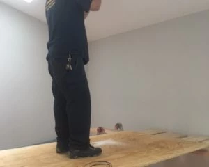 Current electrical contractor taking safety precautions while installing a chandelier